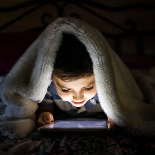 child looking at screen in the dark