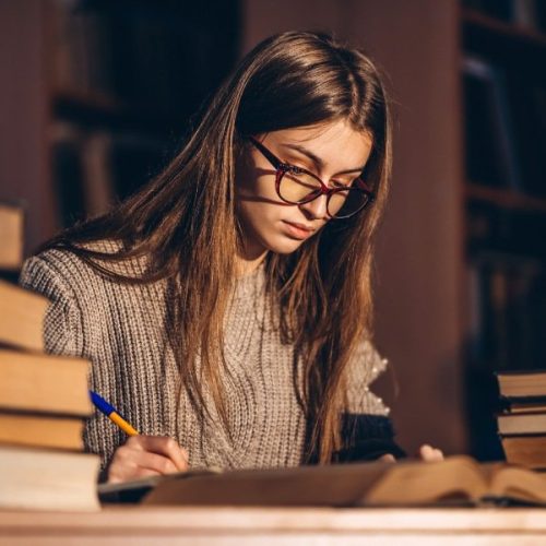 young woman with eyeglasses doing school work